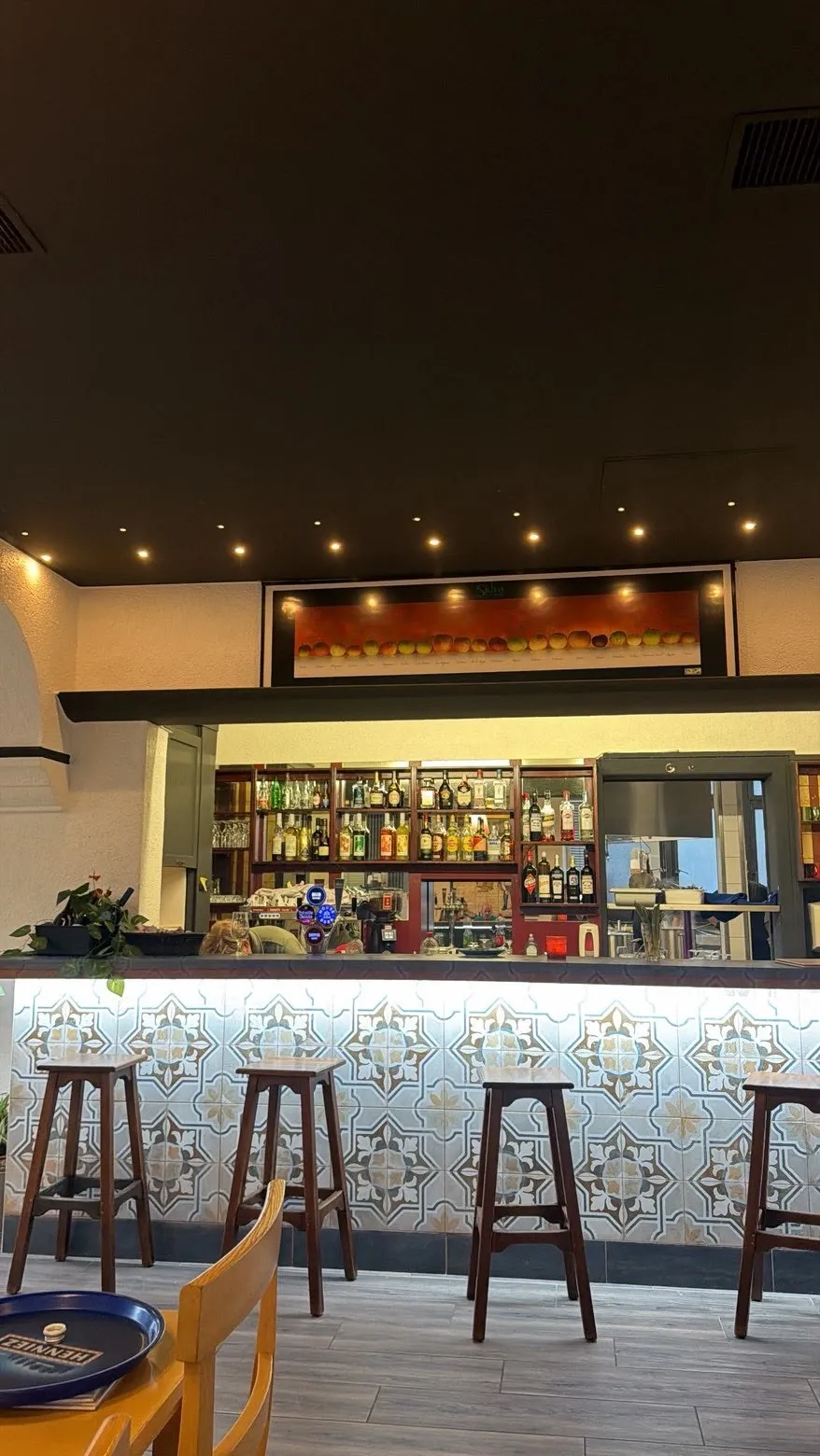 Le bar aux carreaux de céramique, tabourets en bois